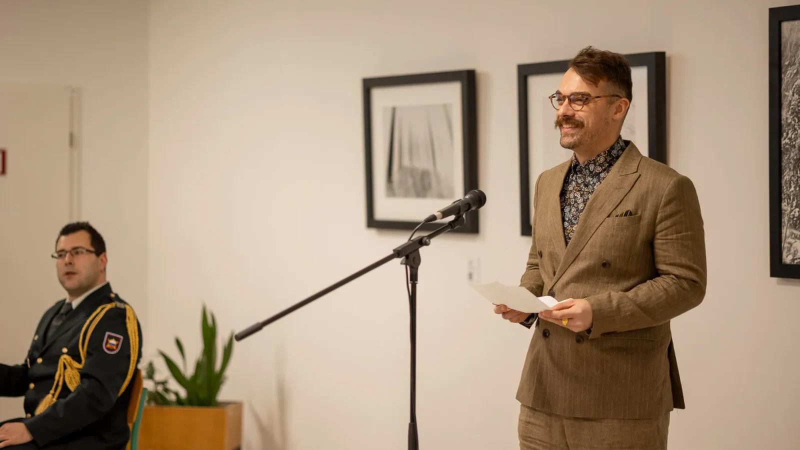 An opening address for Sintropija in front of monochrome photographs.