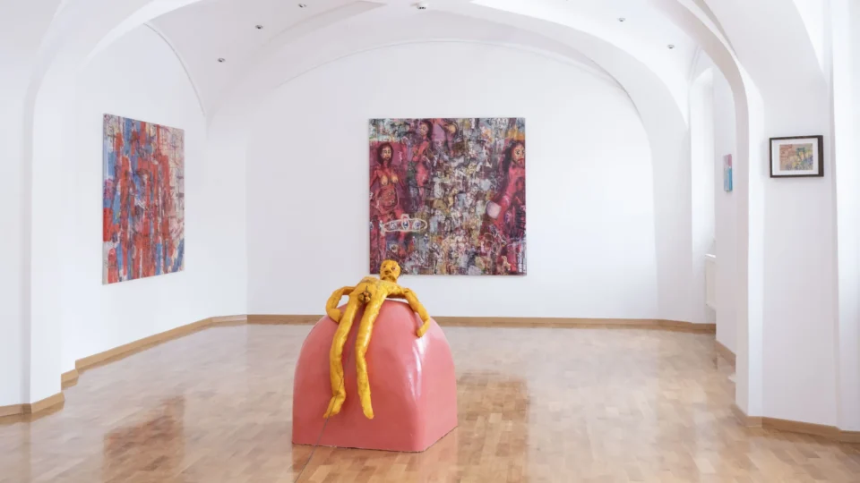 Kiparsko delo in slike v galerijski postavitvi.